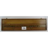 An antique oak billiards score board with hand painted gilt numbers and turned hardwood markers.