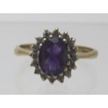 A 9ct gold amethyst & diamond cluster ring, amethyst approx 8mm x 6mm, size P. Condition report: