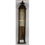 An antique oak cased Admiral Fitzroy's barometer with carved leaf finial. Condition report: Foxing