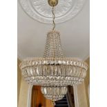 A stunning pair of crystal and gilt brass chandeliers with floral festoons and 15 bulb holders.