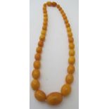 A vintage graduated amber necklace, centre bead approx 15mm x 20mm, screw type clasp, approx 18"