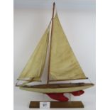 A vintage scratch built single masted pond yacht with mahogany hull and three sail rig. Later