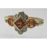 A 9ct yellow gold ring set with centre orange topaz with three small diamonds either side and two