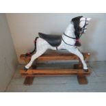 A vintage dapple grey rocking horse with real horsehair mane & tail, raised on a pine stand.