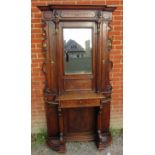 A Victorian oak hall stand with bevelled mirror back flanked by reed columns & brass coat hooks