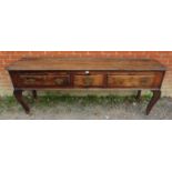 An 18th century oak sideboard/dresser base of immense character, housing one short and two long