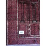 A Turkoman rug on deep burgundy ground with highlights of cream. 2.30 x 1.30. Condition is good.