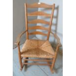 A vintage beech ladder back Pembrokeshire rocking chair with shaped armrests & rush seat, raised
