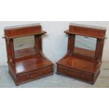 A turn of the century pair of mahogany wall hanging shelves, each with brass rail, inset mirror
