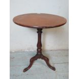 A 19th century mahogany circular tilt top wine table, raised on a baluster turned column with