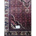 A smart Persian rug. with central motif on a claret field and cream border in very good condition.