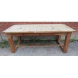 A vintage refectory table with a stripped pine top raised on pitch pine base with chamfered square