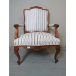 A vintage style French oak open sided armchair raised on scrolled front supports with hoof feet &