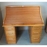 An Art Deco light oak roll top desk, the locking tamba door opening onto a fitted interior with