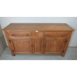 An early 20th century medium oak sideboard in the Cotswolds taste, having two short drawers over two