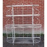 A vintage French wrought metal four tier boulangerie rack with graduated shelving & double scroll