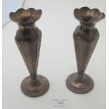 A pair of silver vases having four panels embossed with scrolls around the edge and matching scrolls