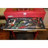 A PORTABLE RED FINISHED TOOL BOX branded 'American Pro' containing a selection of domestic tools