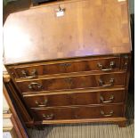 A REPRODUCTION YEW WOOD FINISHED BUREAU of typical form and construction, having graduating four