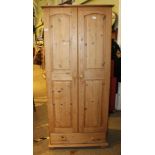 A MODERN PART SCRUBBED PINE TWO DOOR WARDROBE with shoe drawer below