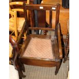 A 20TH CENTURY BEECHWOOD SLAT BACK COMODE ARMCHAIR, retaining ceramic pot