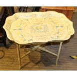 A DECORATIVELY PAINTED DISTRESSED EFFECT COFFEE TABLE on folding painted wooden stand