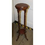 A MAHOGANY FINISHED CIRCULAR TOPPED JARDINIERE STAND supported on four barley twist uprights