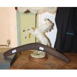 A HAND CARVED BOOMERANG together with a decorative table light in the form of a prancing white horse