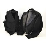 AN EARLY 20TH CENTURY CHILD'S TAILOR MADE BLACK JACKET with satin lapels, a waistcoat and a bow tie,