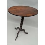 A 19TH CENTURY MAHOGANY SNAP TOP WINE TABLE, on turned stem and tripod supports, oval top 53cm x