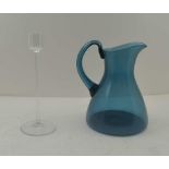 A 'KING'S LYNN' BLUE TINTED GLASS JUG AND FINE STEMMED CLEAR GLASS CANDLE STAND, 20cm high (2)