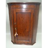 A GEORGIAN DESIGN OAK SINGLE DOOR HANGING CORNER CABINET, 60cm wide, 84cm high