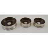 W.I. BROADWAY & CO. THREE SILVER GALLERY BOTTLE COASTERS, turned wood bases, engine turned