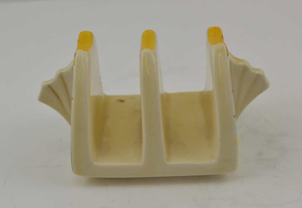 A CLARICE CLIFF POTTERY TWO SECTION TOAST RACK of Art Deco form, hand painted decoration of lines