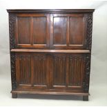 A 20TH CENTURY OAK COCKTAIL CABINET, in the 17th century style, with linen fold and blind fret
