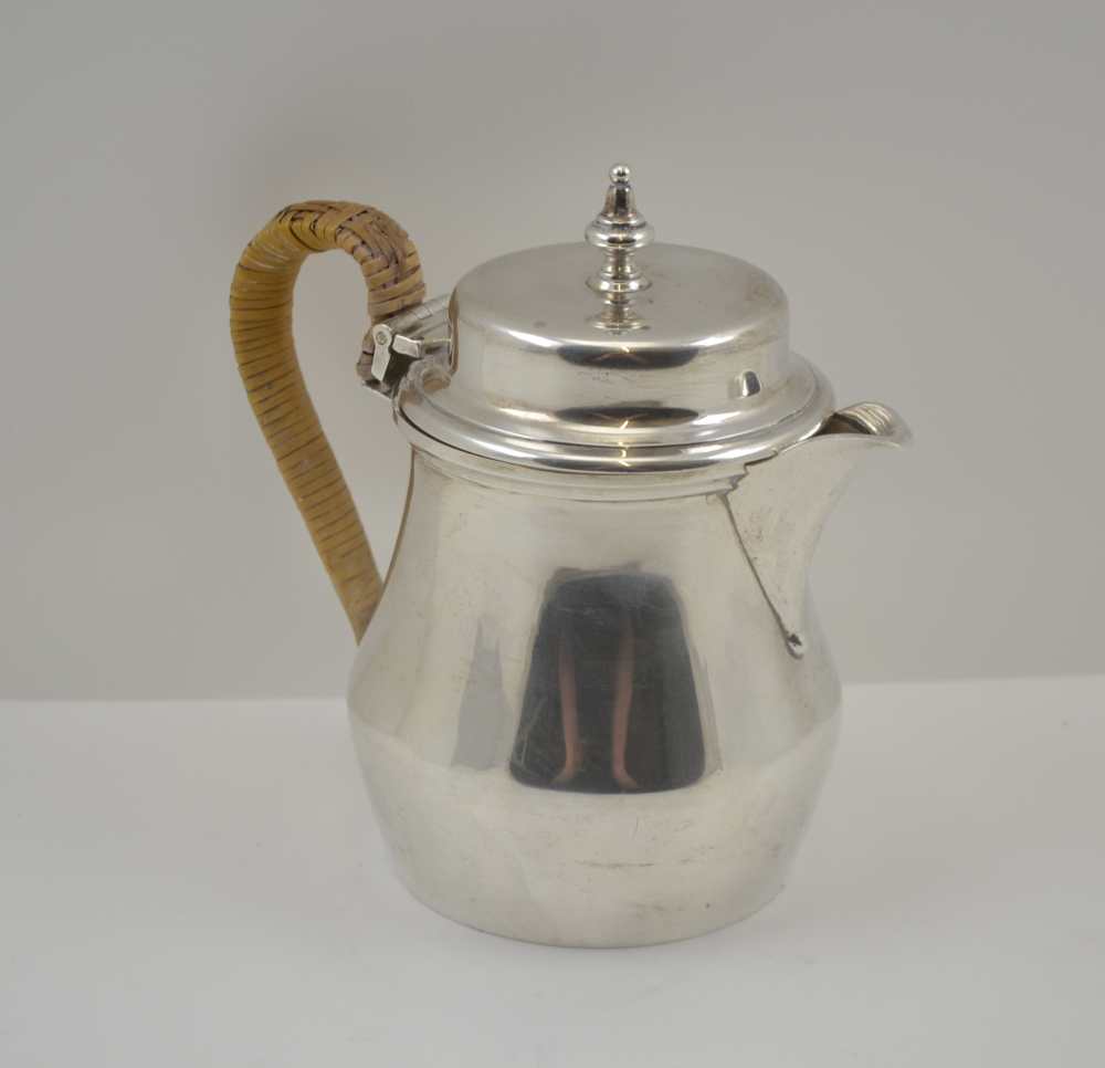 WILLIAM COMYNS & SONS LTD AN EARLY 20TH CENTURY SILVER LIDDED HOT WATER / MILK JUG with cane bound