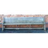 A LATE 19TH CENTURY WEATHERED PINE LONG PEW, having shelf bac