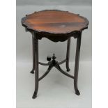 A FIRST QUARTER 20TH CENTURY MAHOGANY FINISHED FANCY TOPPED TABLE, supported on four gently outswept