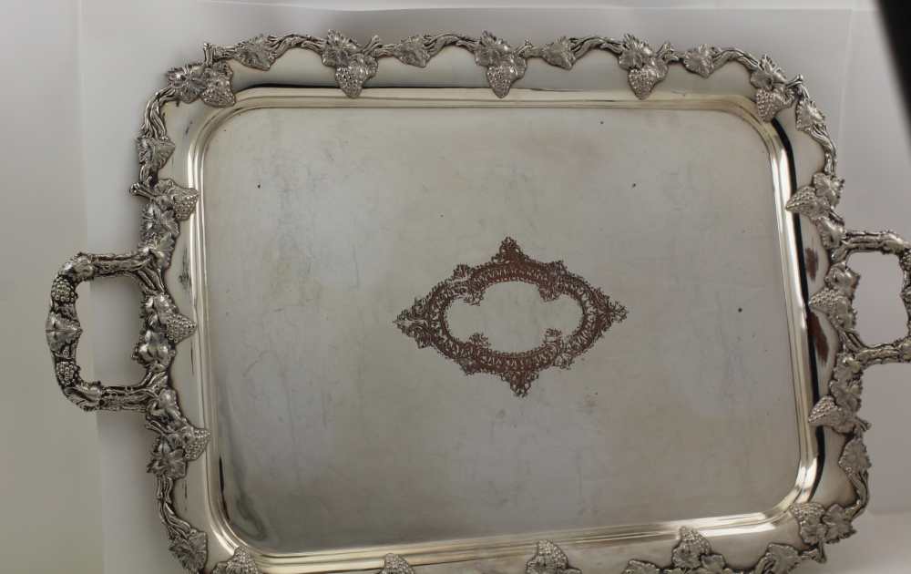 AN EARLY 20TH CENTURY SILVER PLATE ON COPPER TWO-HANDLED TEA TRAY, with cast fruiting vine rim and