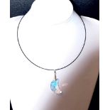 A SWAROVSKI CRESCENT MOON CRYSTAL set on a pale blue ribbon with floral clasp (in presentation box)