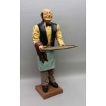 A LATE 20TH CENTURY COMPOSITE FLOOR STANDING FIGURE OF A WAITER with a vacant tray, 92cm high (
