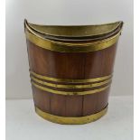 AN EARLY 19TH CENTURY IRISH MAHOGANY PEAT BUCKET of elliptical form, coopered construction, with