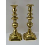 A PAIR OF 19TH CENTURY BRASS CANDLESTICKS, raised on square canted bases, 30cm high