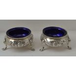 A PAIR OF VICTORIAN SILVER SALTS, London 1876, floral decoration, with blue glass liners, combined