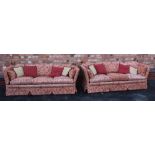 A PAIR OF KNOLE DESIGN PETER GUILD BRANDED THREE PERSON SETTEES, having old gold and dusky red