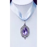 A SWAROVSKI TEARDROP CRYSTAL, set on a decorative white metal pendant mounted on a