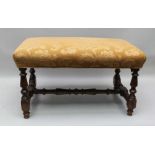 A 19TH CENTURY RECTANGULAR PAD TOP STOOL, supported on fancy turned and blocked legs, united by