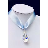 A SWAROVSKI FACET CRYSTAL mounted upon a pale blue ribbon with clasp (in presentation box)