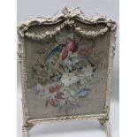 A 19TH CENTURY FIRESCREEN having glazed wool work panel depicting a parrot amongst floral foliage,