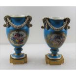 A PAIR OF 19TH CENTURY FRENCH CERAMIC VASES, of urn form, with acanthus scroll handles, wreath
